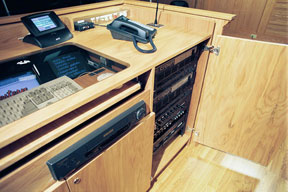 The VCR is mounted below the pull-out computer keyboard.  On the right is the electronics rack for the theater style audio system and related digital control equipment.